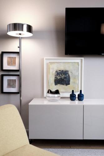 a living room with a white cabinet with a tv on it at SAXX Apartments "Goldberg Karree" in Hagen
