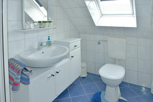 un bagno bianco con un water e un lavandino di Ferienwohnung Sonnenberg, 25502 a Weener