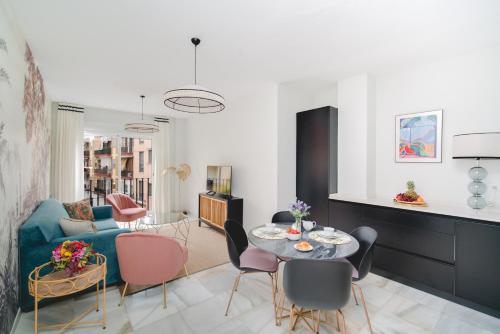 a living room with a blue couch and a table at Arco Macarena Suite in Seville