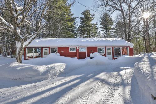 ein rotes Haus ist mit Schnee bedeckt in der Unterkunft Roadside Duplex in Arbor Vitae