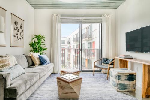 a living room with a couch and a large window at Lodgeur at Mid Main Lofts in Houston
