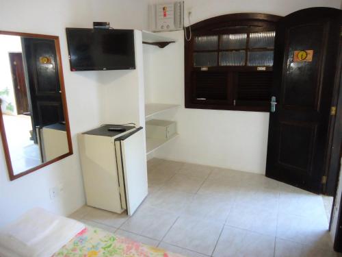 a small kitchen with a refrigerator and a microwave at Pousada L'étage in Búzios
