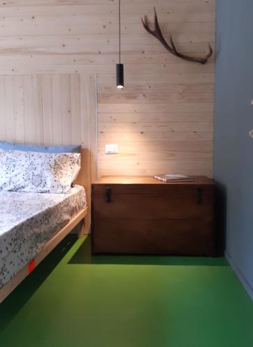 a bedroom with a bed and a wooden wall at Maison 4 soleil. Casa design luce e natura in Crodo