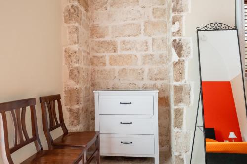 a room with a brick wall and a white dresser at B&B Santi Medici in Bitonto