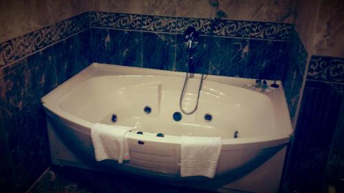a bath tub with a shower in a bathroom at Kumburgaz Blue World Hotel in Büyükçekmece