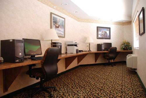 a hotel room with two desks with computers and chairs at Holiday Inn Express Hotel & Suites Raton by IHG in Raton