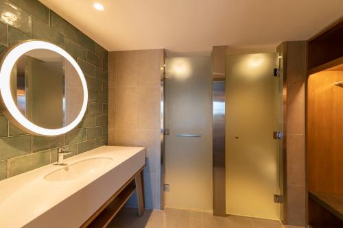 a bathroom with a sink and a mirror and a shower at Holiday Inn Express & Suites Queenstown by IHG in Queenstown