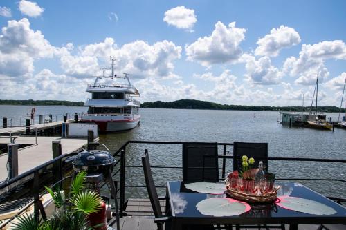 a boat is docked at a dock with a table at Island-dreams Hausboot Cecilie in Schleswig