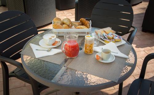 - une table en verre avec un plateau de petit-déjeuner dans l'établissement Relais Corte Bergamini, à Peschiera del Garda