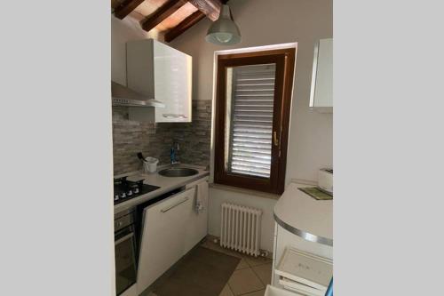 a kitchen with white cabinets and a sink and a window at Casa di Adele in Chiaravalle