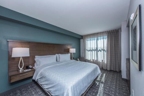 a bedroom with a large bed and a large window at Staybridge Suites Charleston - Mount Pleasant by IHG in Charleston