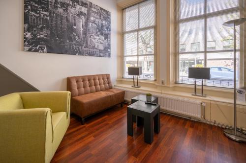 a living room with a couch and a table at Flonk Hotel Groningen Centre, BW Signature Collection in Groningen