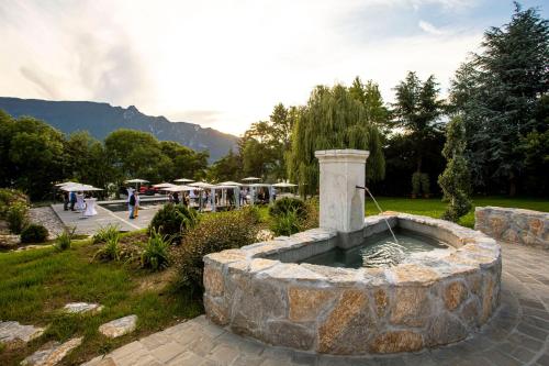 a stone fountain in the middle of a park at Hôtel L'Incomparable Aix-Les-Bains in Tresserves