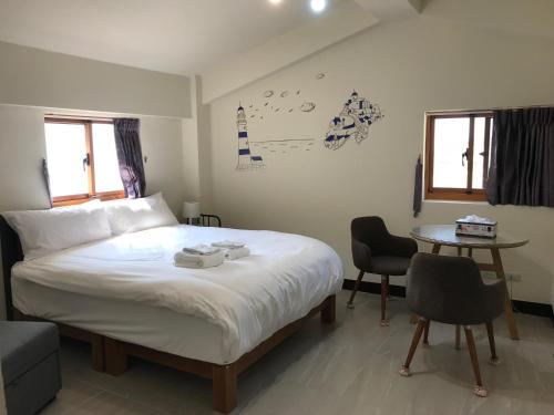 a bedroom with a bed and a table with chairs at Yo Ho 23 Homestay in Beigan