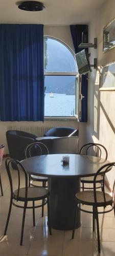 a dining room with a table and chairs and a window at Casa Romani Lake Apartments in Nago-Torbole