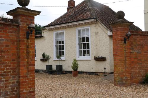 a house with two windows and a brick wall at Prince Hill House in Devizes