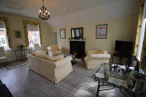 a living room with two couches and a tv at Prince Hill House in Devizes
