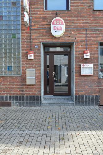 a front door of a brick building with a sign on it at Pension "Zur Traube" in Bergheim