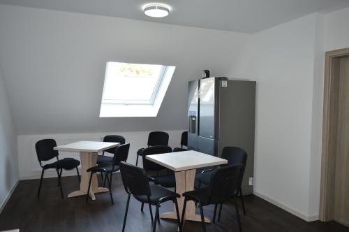 Zimmer mit 2 Tischen und Stühlen sowie einem Kühlschrank in der Unterkunft Pension Zur Traube in Bergheim