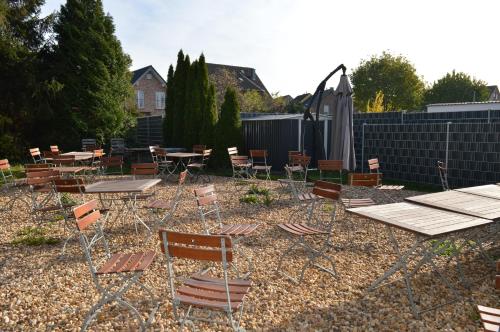 einen Garten mit Stühlen, Tischen und einem Zaun in der Unterkunft Pension Zur Traube in Bergheim