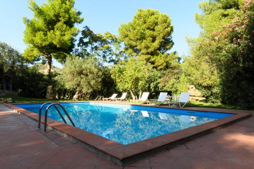 uma piscina num quintal com cadeiras e árvores em Dattilo em Torre Melissa