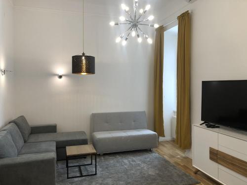 sala de estar con sofá y TV en PULSE OF VIENNA by JR City Apartments, en Viena