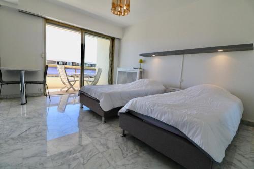 une chambre avec deux lits et une télévision à écran plat dans l'établissement 2 bedroom & studio Palais Royal 2 mins from Croisette and Carlton, à Cannes