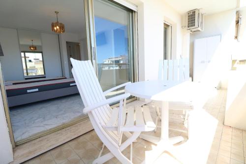 une salle à manger avec une table et des chaises blanches dans l'établissement 2 bedroom & studio Palais Royal 2 mins from Croisette and Carlton, à Cannes