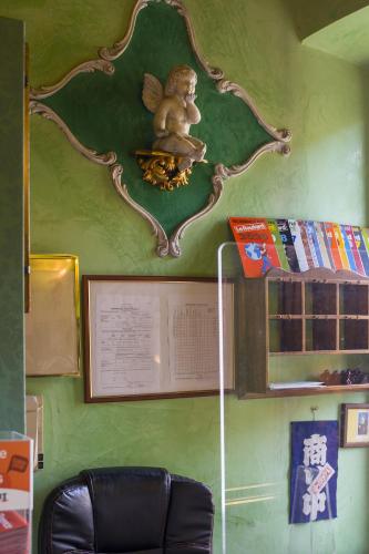 a green wall with a statue on the wall at Hotel Abaco in Florence