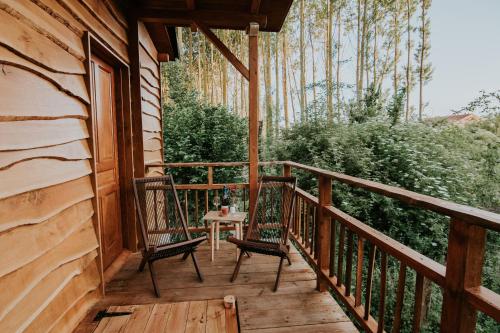 a porch of a cabin with two chairs and a table at Bonita cabaña de los arboles en La Rioja , Durmiendo entre arboles in Anguciana
