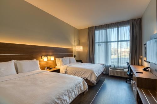 a hotel room with two beds and a flat screen tv at Holiday Inn Express & Suites - Charlotte - South End by IHG in Charlotte