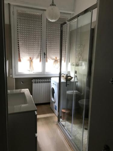 bagno con doccia, lavandino e lavatrice di Casa Marconi a Lovere