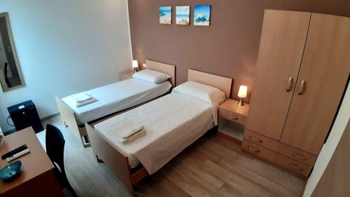 een kleine kamer met 2 bedden en een bureau bij B&B Filieri in Santa Maria al Bagno