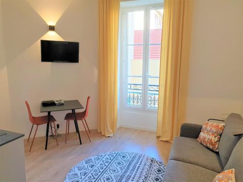 un salon avec un canapé, une table et une fenêtre dans l'établissement STUDIO HYPERCENTRE-201, à Nice