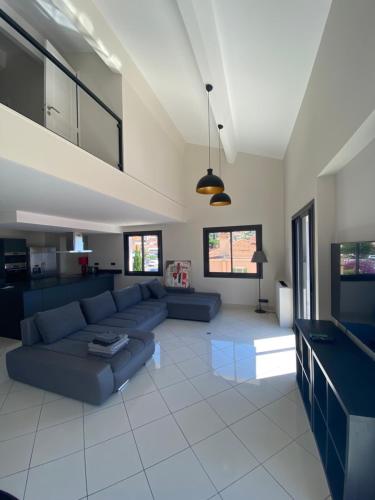 a living room with a couch and a tv at Résidence Le Provence in Le Lavandou