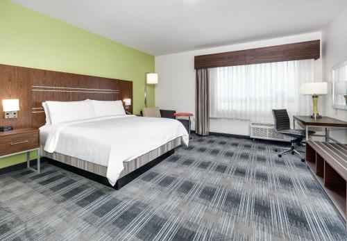 a hotel room with a bed and a desk at Holiday Inn Express & Suites Dallas NW - Farmers Branch by IHG in Farmers Branch