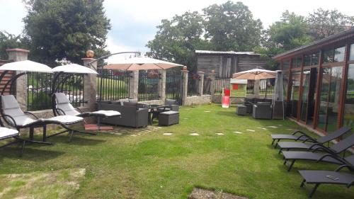 a yard with chairs and tables and umbrellas at Lakata Guest House in Zasele