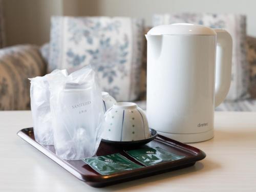 a table with a cell phone and a coffee mug at Tabist Katahara Resort Gamagori in Gamagori
