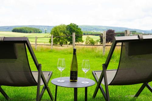 a bottle of wine sitting on a table with two glasses at B&B Domaine du Vieux Chêne in Stoumont