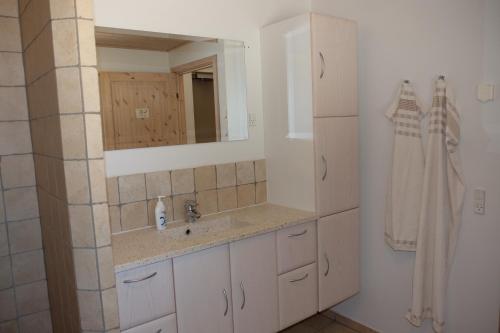 W łazience znajduje się umywalka i lustro. w obiekcie Billund Rooms w Billund