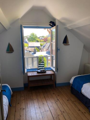 um quarto com uma janela com uma cama e um banco em Stella Etretat em Étretat