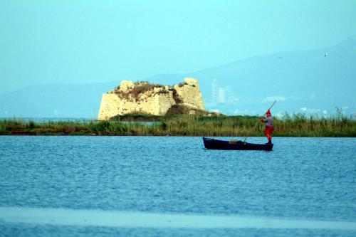 a man is standing in a boat on the water at Albaga in Sant Jordi