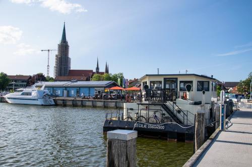 a boat is docked at a dock in the water at Island-dreams Hausboot Cecilie in Schleswig