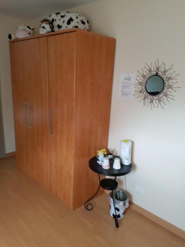 a cabinet with a small table in a room at Chambres d'Hôtes Arques en Ciel in Arques-la-Bataille