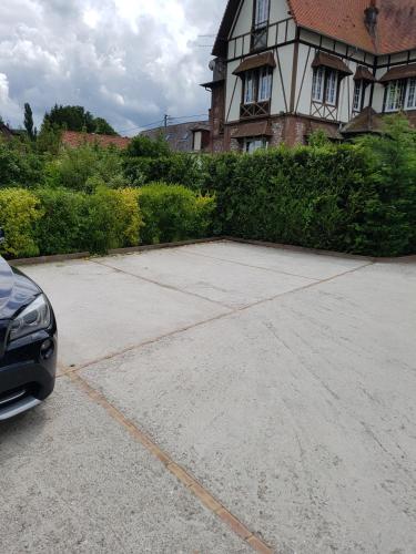 a car parked in a parking lot in front of a house at Chambres d'Hôtes Arques en Ciel in Arques-la-Bataille