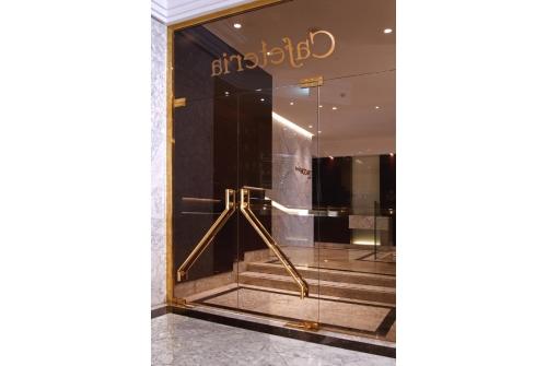 an entrance to a store with a gold revolving door at Hotel Mozart in Valladolid