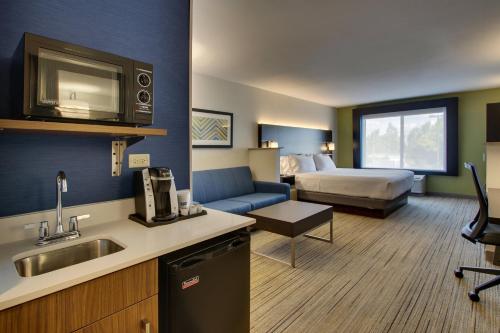 a hotel room with a kitchen and a room with a bed at Holiday Inn Express Hotel & Suites Morris, an IHG Hotel in Morris