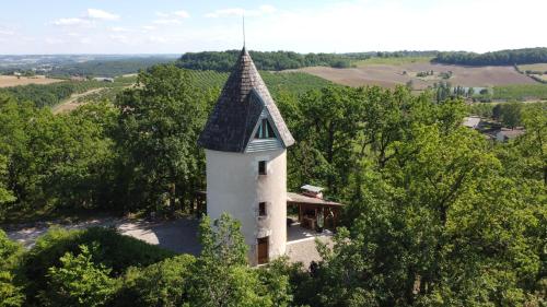 uma vista aérea de uma casa com uma torre em Moulin De Rouzé em Castelnaud-de-Gratecambe