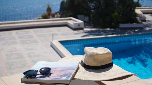 a hat sitting on top of a table next to a pool at Residence Terra Rossa Taormina in Taormina