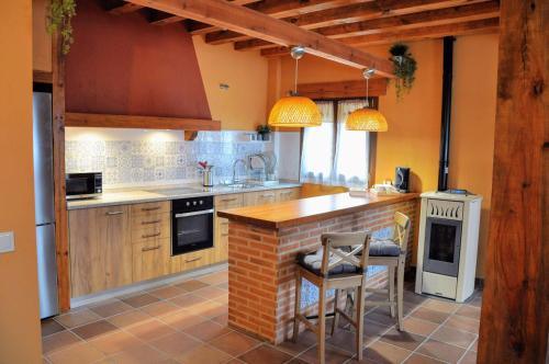 a kitchen with a counter and chairs in it at LA FUENTE DE CABANILLAS in Cabanillas del Monte